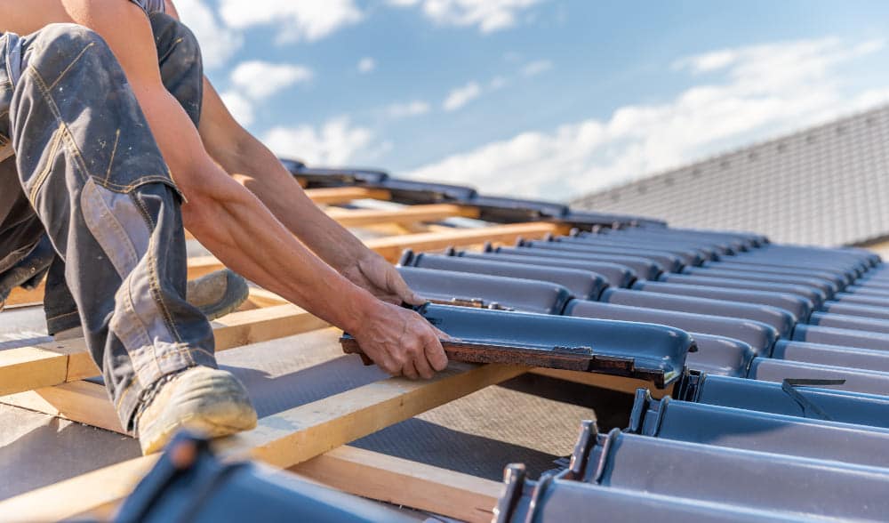 Roofer Laying Roofing Tiles on a Roof