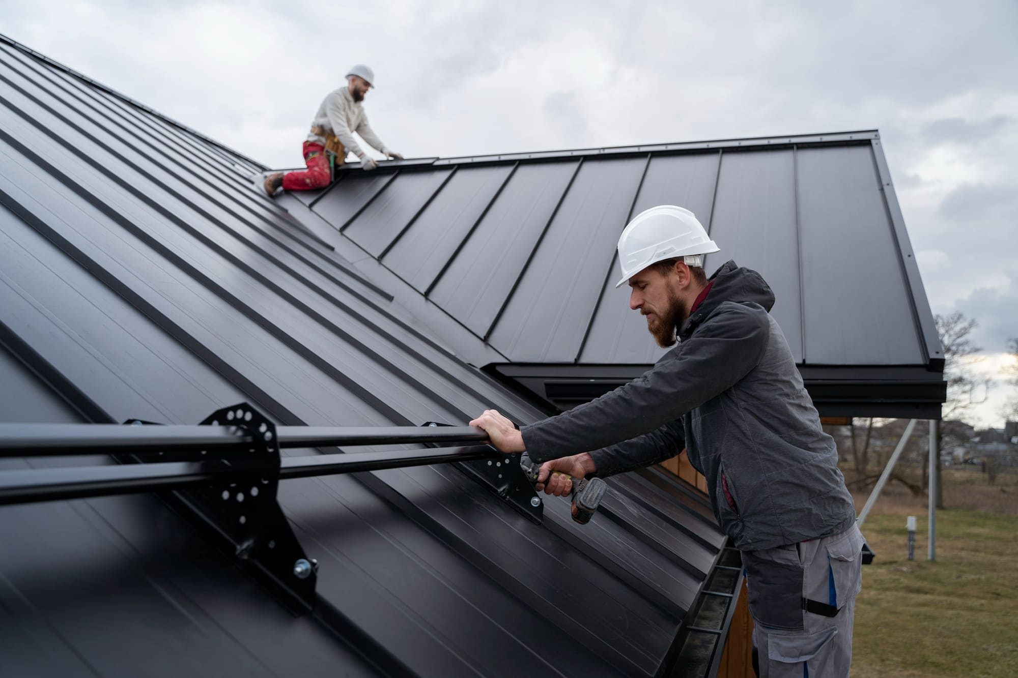 2 Roofers Working on Metal Roof