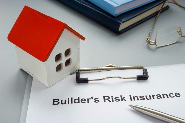 Risk Builders Insurance on paper with plastic house on clipboard.