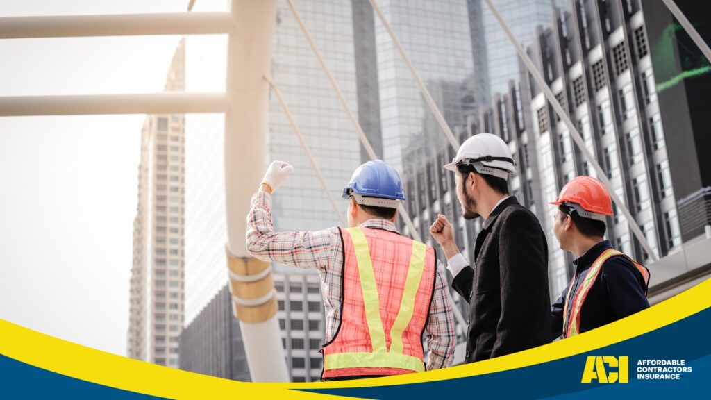 Contractors in orange safety vest and hard hat at a construction site, with cranes. Contractors Insurance Glossary.